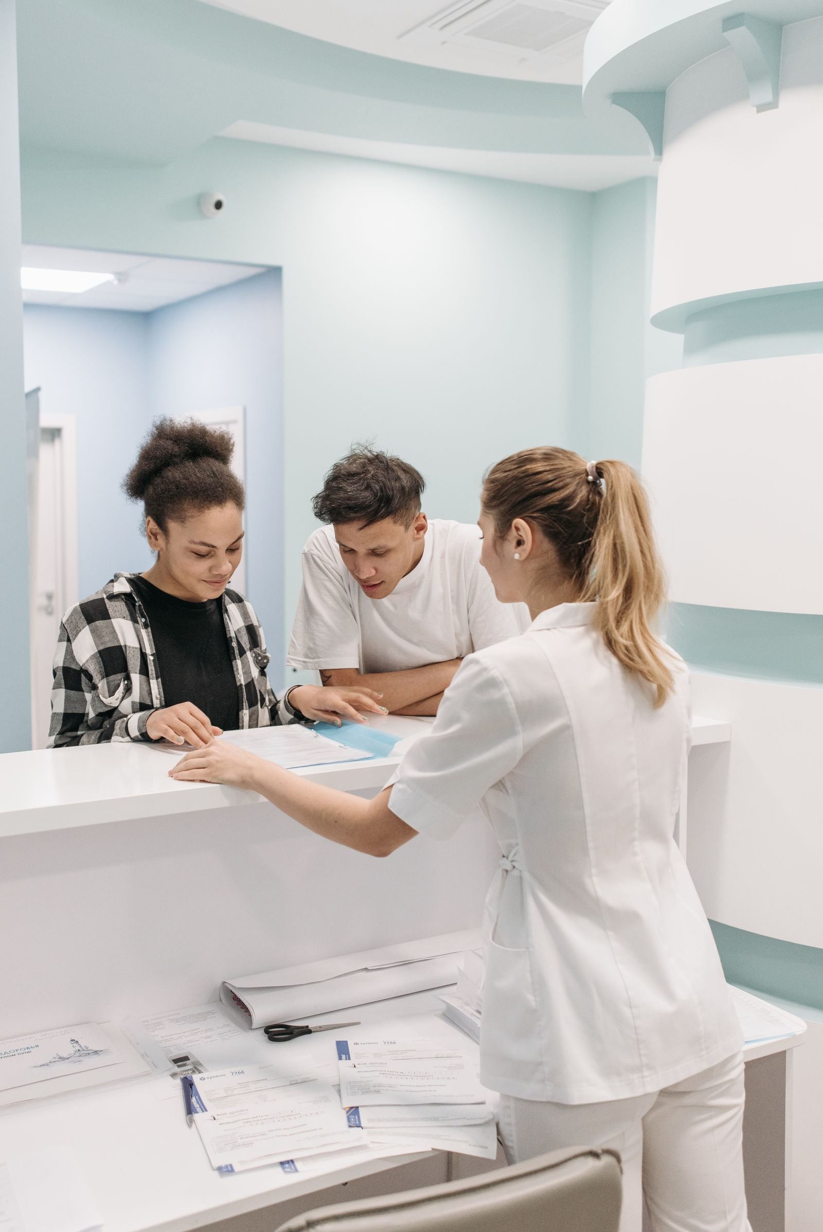 Clinic front desk staff assisting patients, the kind of reception work an AI receptionist can support after hours